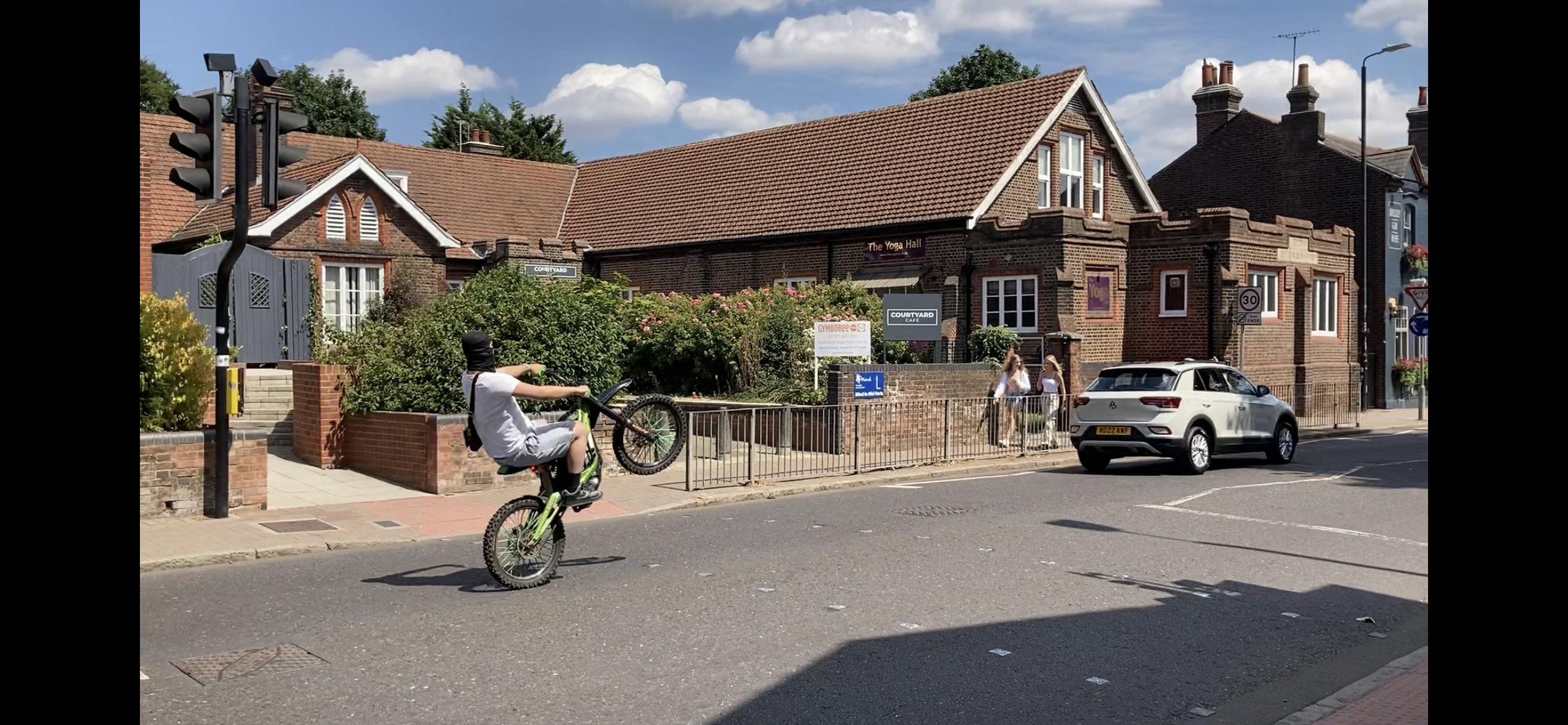 A biker performing a wheelie in Hatfield Road.