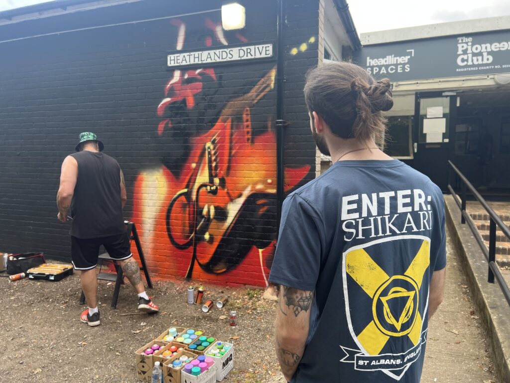 Ant Steel working on a mural at The Pioneer Club.