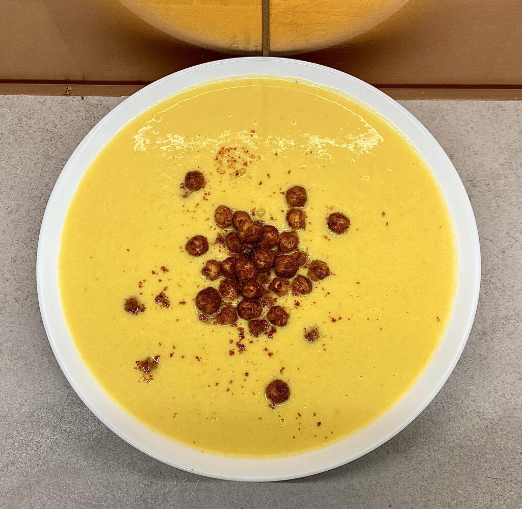 Spiced chickpea garnish added to soup.