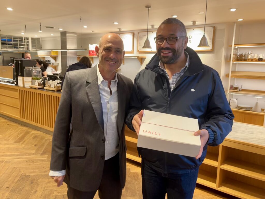 Nigel Gardner presents James Cleverly with cakes for his security detail.