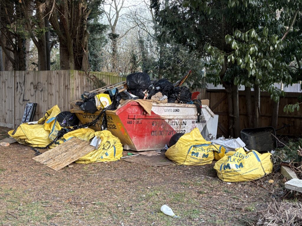 Fly-tipped rubbish in a skip at Five Acres.