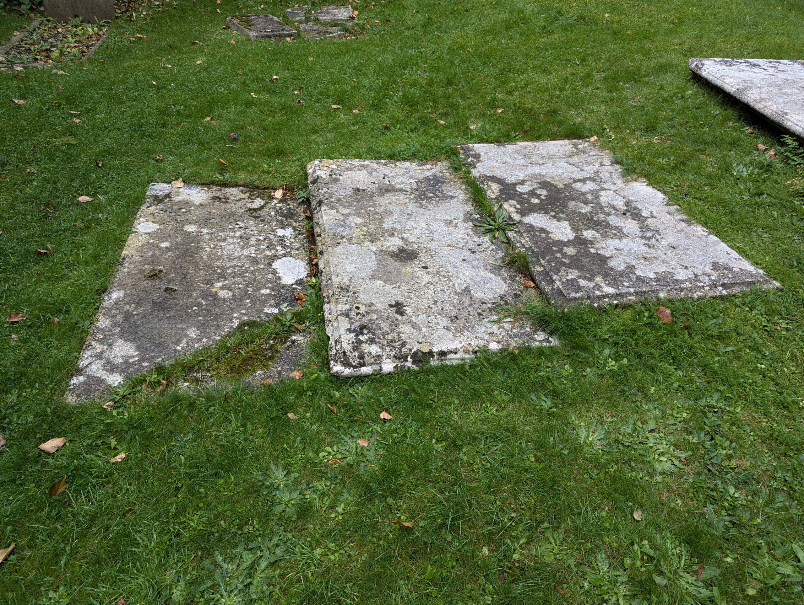 The weathered gravestones of Nathaniel Cotton and his wives in St Peter's Churchyard.