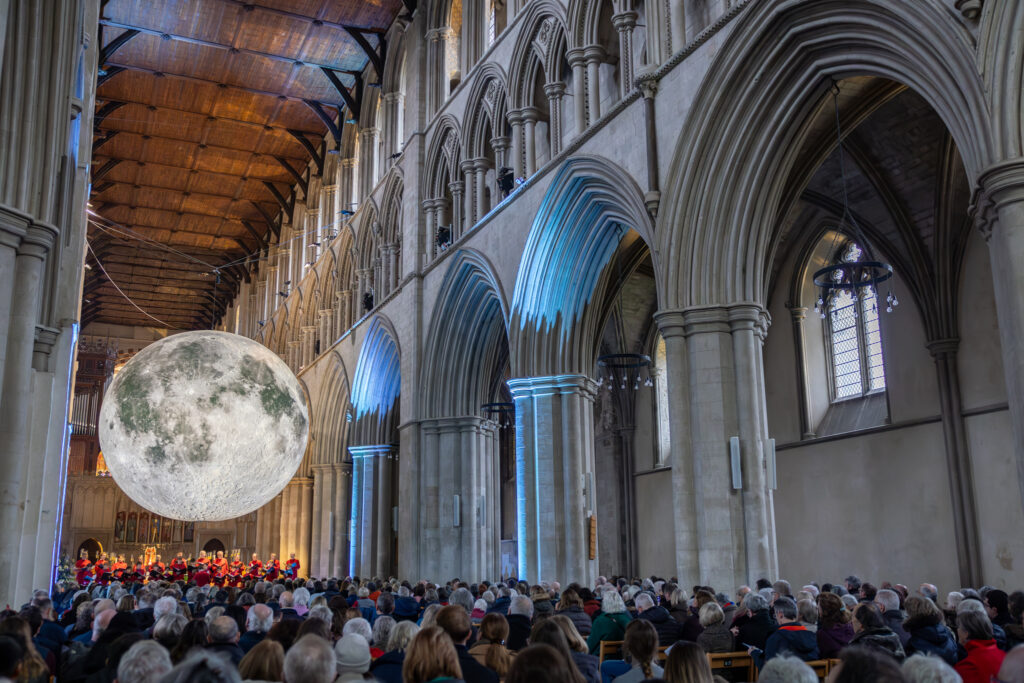 Cathedral choristers singing beneath the Moon. Photo: Toby Shepheard.