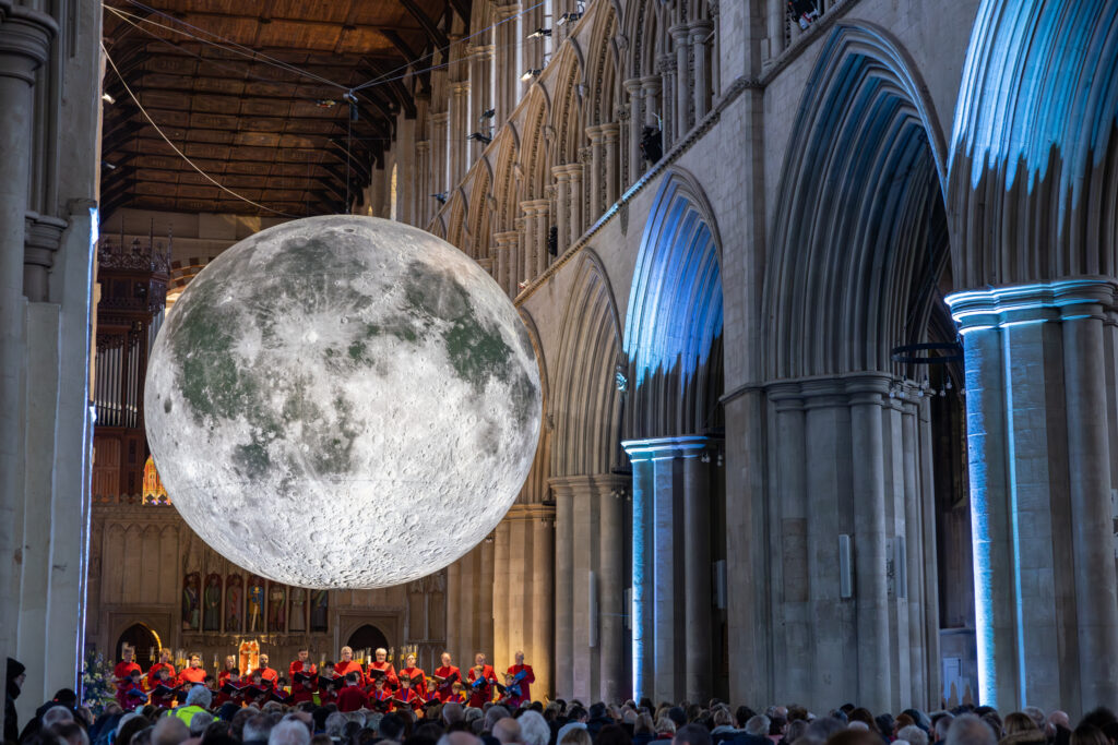 Cathedral choristers singing beneath the Moon. Photo: Toby Shepheard.