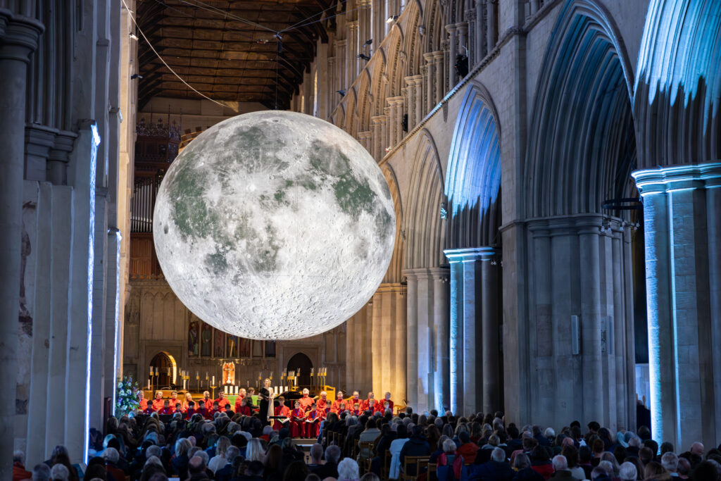Cathedral choristers singing beneath the Moon. Photo: Toby Shepheard.