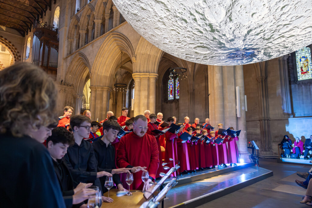 Cathedral choristers singing beneath the Moon. Photo: Toby Shepheard.