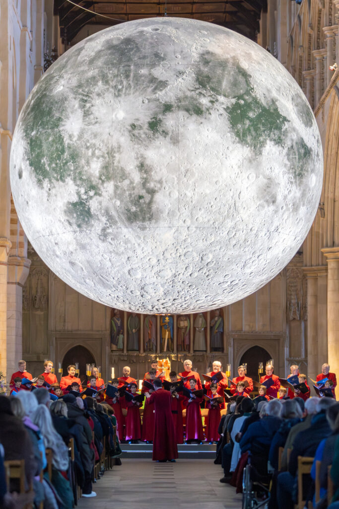 Cathedral choristers singing beneath the Moon. Photo: Toby Shepheard.