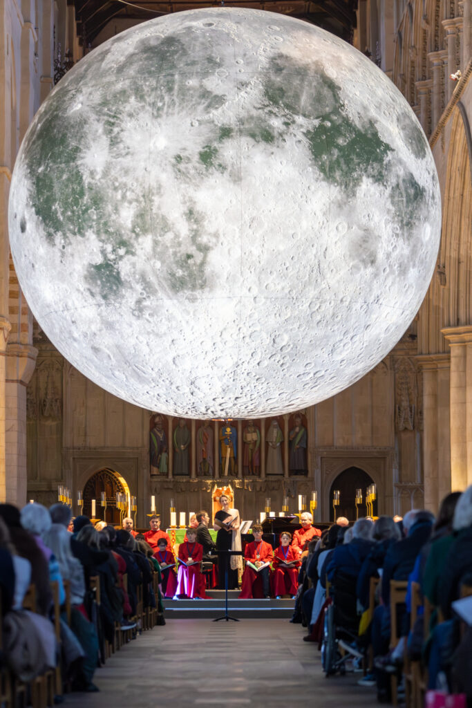 Cathedral choristers singing beneath the Moon. Photo: Toby Shepheard.
