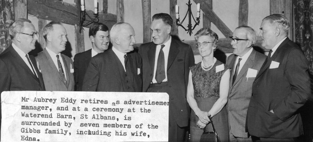The retirement of advertising manager Aubrey Eddy was marked with a ceremony at the Waterend Barn. He is surrounded by seven members of the Gibbs family, including his wife Edna.