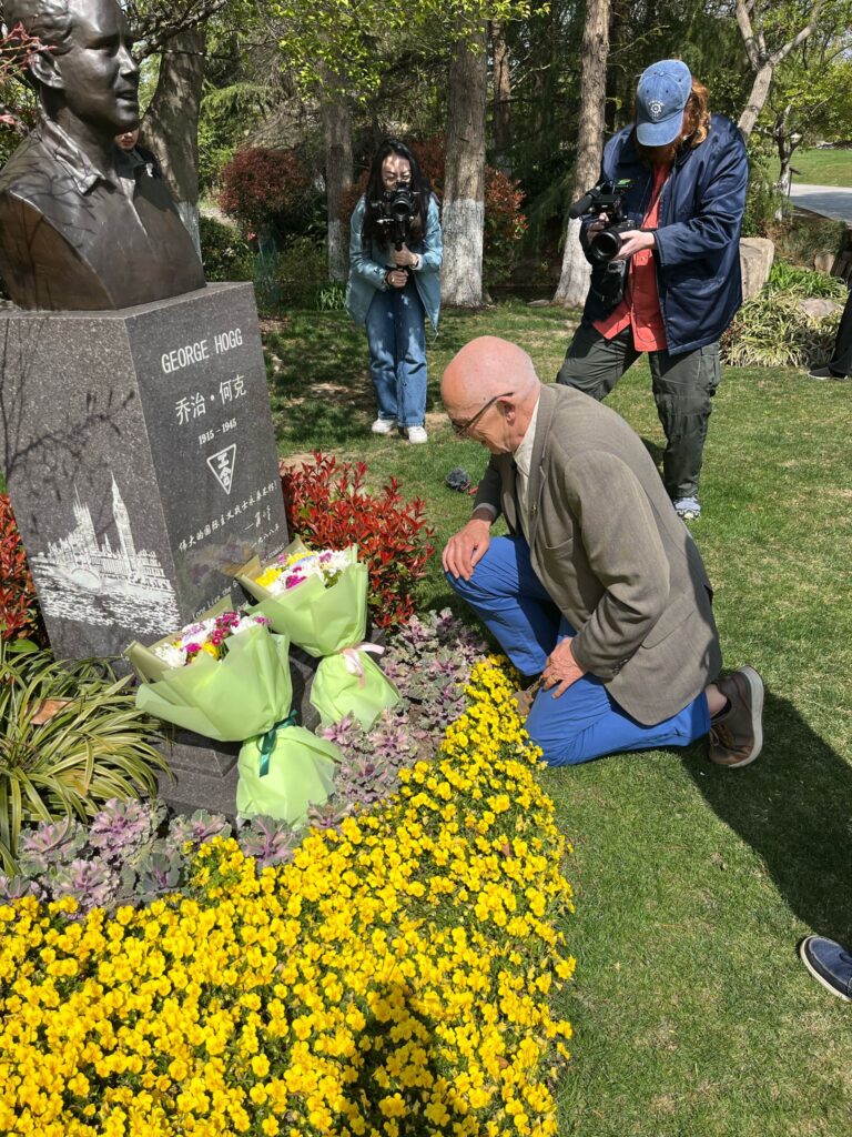 Mark Thomas laying flowers at Hogg's memorial in Shanghai