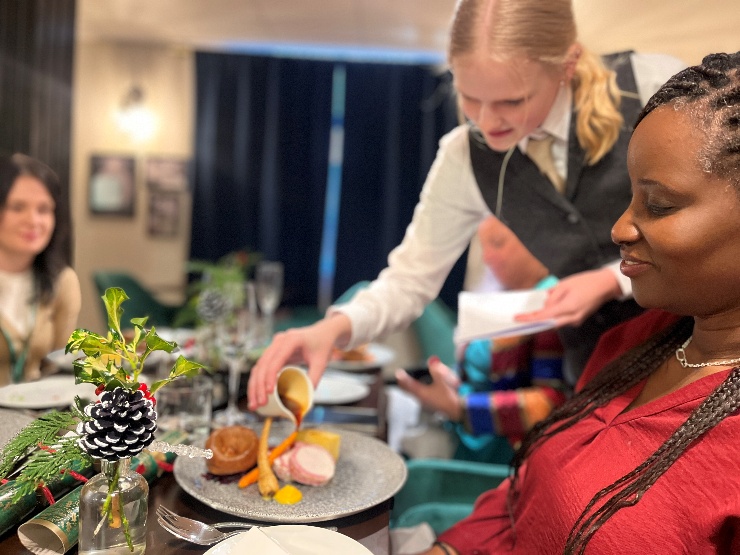 Students serving food in The Stables restaurant.