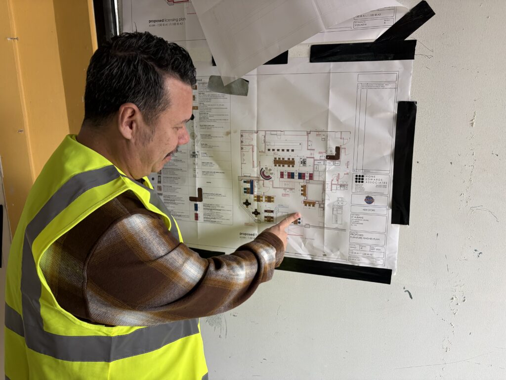 Chris Cheah shows off the plans for the new restaurant.