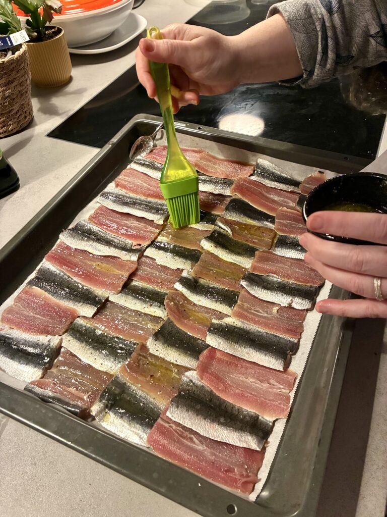 Brushing sardines with oil
