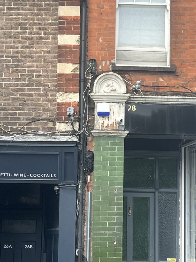 Why is there a cow relief on the side of 28 Station Road in Harpenden?